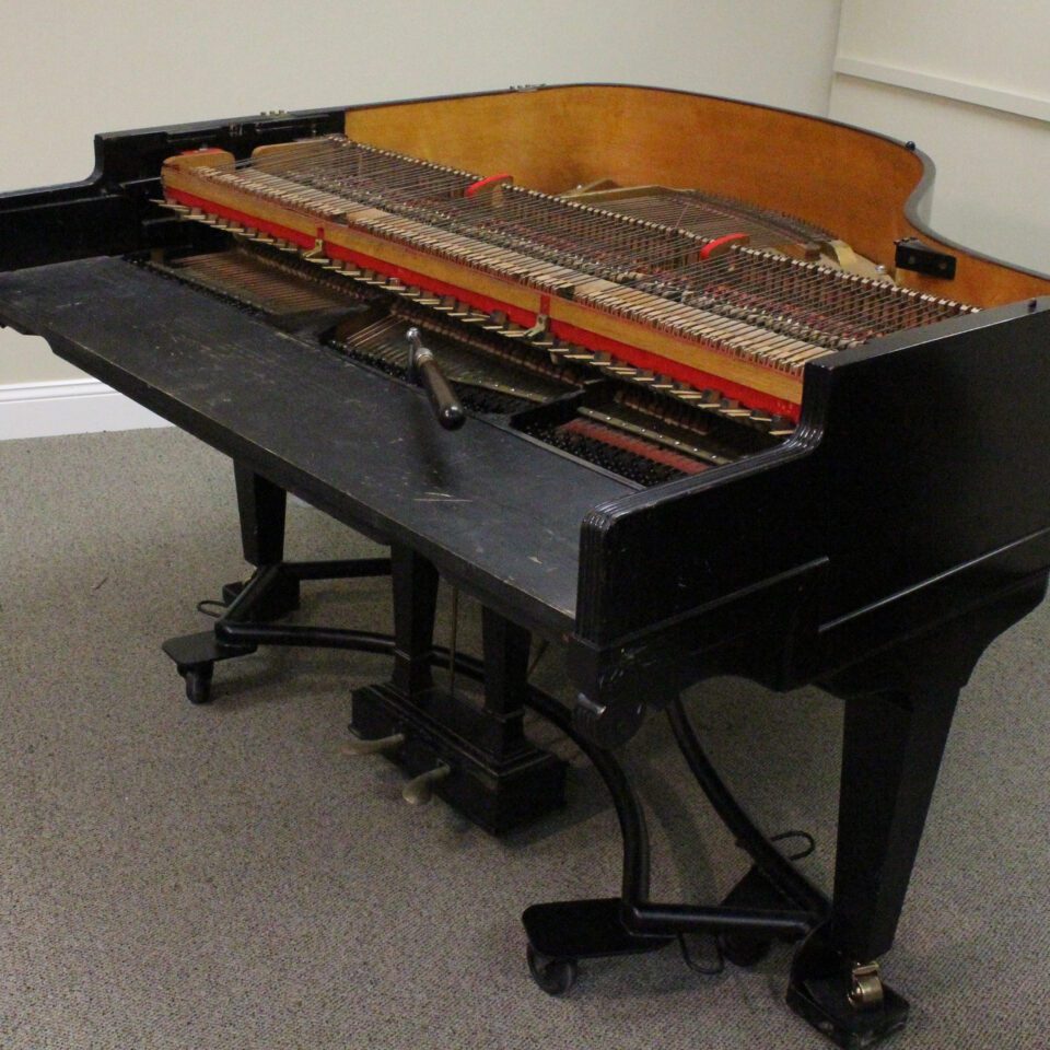 George Rogers down striking grand piano with tuning removed